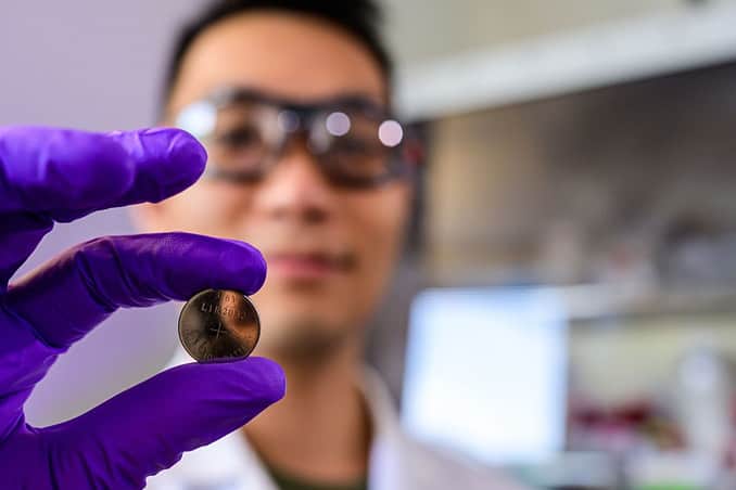 Quan Nguyen holds one of the batteries assembled using the prelithiation protocol described in the study. (Photo by Jeff Fitlow/Rice University)